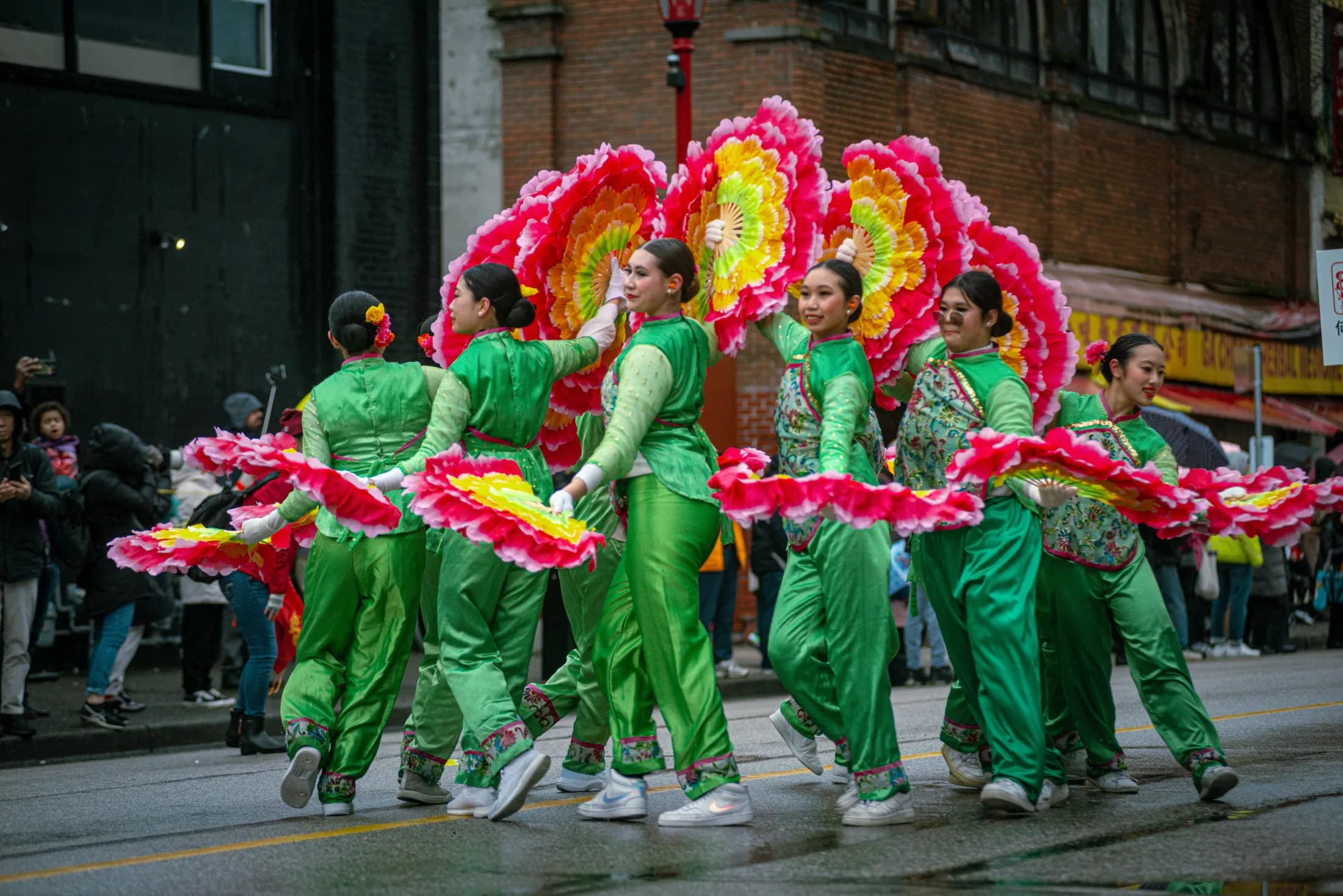 Dancers in green festival dress during a street procession