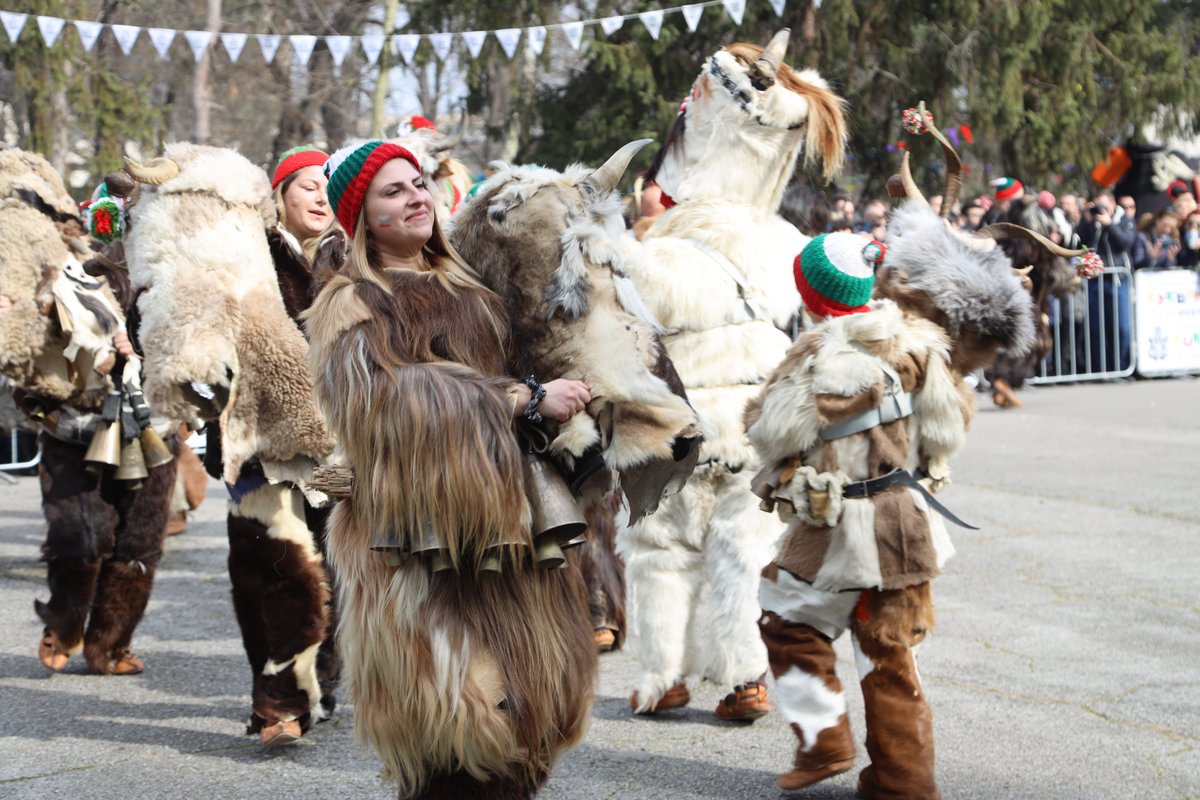 Traditional Kukeri mummers in elaborate costumes with bells performing ritual dance in Bulgaria